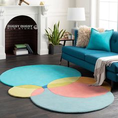 a living room with a blue couch and colorful rugs on the hardwood flooring