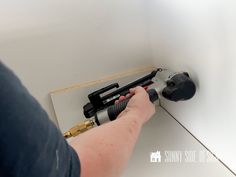 a person using a drill to fix a wall