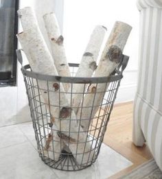 a basket filled with logs sitting on top of a white floor next to a window