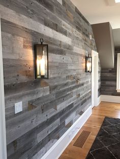 a wooden wall with two lanterns on the side and a rug in front of it