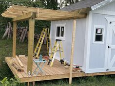 a small white shed with a ladder on the side and windows in the roof area