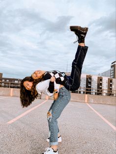 two young women are posing for the camera in an empty parking lot