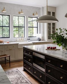 a large kitchen with marble counter tops and wooden cabinets, along with an island in the middle