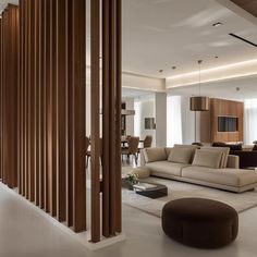 a living room filled with furniture and wooden slats on the wall next to a stair case