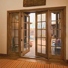 an open wooden door with glass panes on the outside and wood floors in front