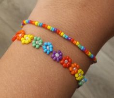 a woman's arm with a colorful bracelet on top of it and beads around the wrist