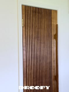 a wooden door with the word dropop on it in front of a white wall