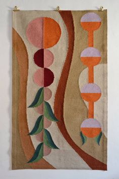 a wall hanging on the side of a white wall with an orange and pink design