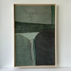 a painting hanging on the wall in a room with white walls and a wooden frame