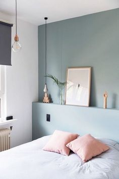 a bedroom with blue walls and pink pillows