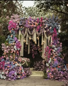 an outdoor wedding ceremony decorated with flowers and tassels