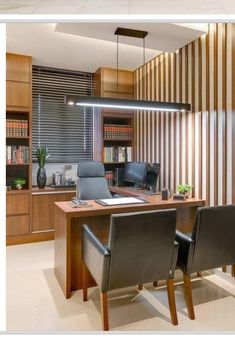 an office with two chairs and a desk in front of a book shelf filled with books