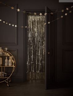 a black room with gold stars hanging from the ceiling and a round table in front of it