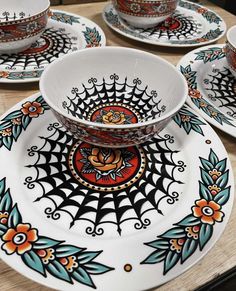 a table topped with plates and cups covered in spider web designs