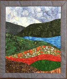 a quilted landscape with flowers and hills in the background