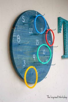 a wooden clock with numbers and rings on it