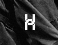 black and white logo with the letter h on it's left side, in front of a dark background