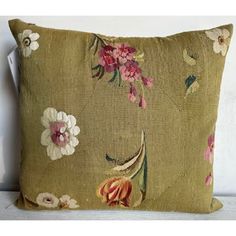 a green pillow with pink and white flowers on it