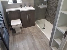 a bathroom with a toilet, sink, and shower stall is shown in this image