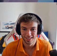 a young man wearing headphones and an orange shirt