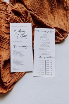 two wedding programs are laying on top of a brown cloth covered tablecloth with the names of their guests