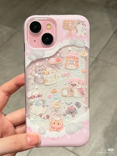 someone is holding up their phone case with many stickers on it, including cats and kittens