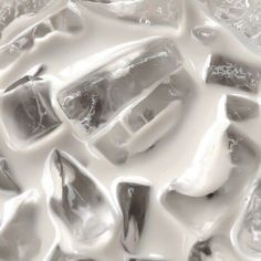 some ice cubes sitting on top of each other in white and gray liquid or water