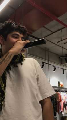 a man holding a microphone up to his mouth while wearing a scarf around his neck