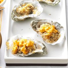 several oysters on a white platter with mustard and cheese crumbs in the middle