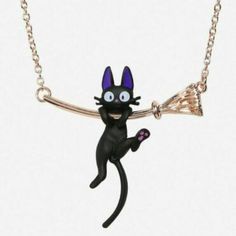 a black cat is holding a broom on a gold plated chain with an evil look