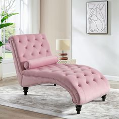 a pink chaise lounge chair sitting on top of a rug