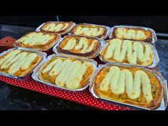 several trays filled with food sitting on top of a table