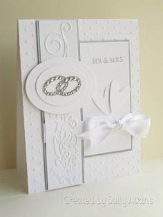 a wedding card with a white bow on the front, and two initials on the back