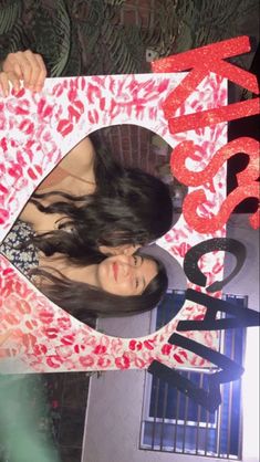 a woman holding up a sign with the word happy birthday written in red on it