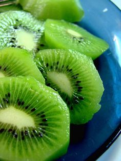 sliced kiwis on a blue plate with a fork