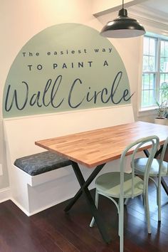 a dining room table with chairs and a sign on the wall above it that says, the best way to paint a wall circle