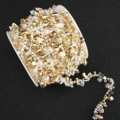 a pile of gold colored crystals sitting on top of a black table next to a chain