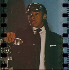 a man in a suit and tie is holding a glass with something on top of it