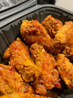 a plastic container filled with fried chicken wings