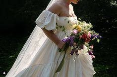 a woman in a wedding dress holding a bouquet