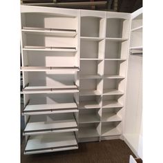 an empty white bookcase in the corner of a room