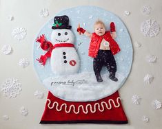 a child standing next to a snowman on top of a red and white plate