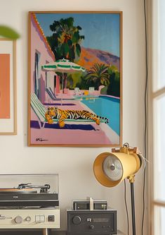 a record player sitting on top of a table next to a painting