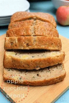 slices of bread sitting on top of a cutting board next to an apple and another plate