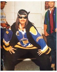 the hockey player is posing for a photo with other people behind her and wearing sunglasses