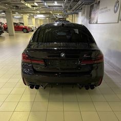 the back end of a black car in a parking garage