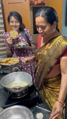 two women are preparing food on the stove