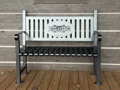 a white bench sitting on top of a wooden floor next to a gray brick wall