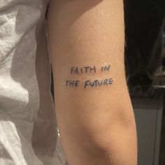 a person with a tattoo on their arm that says faith in the future written on it