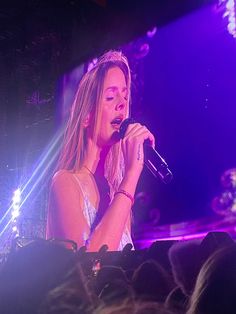 a woman singing into a microphone at a concert